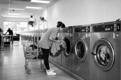 Attended self-service laundromat with commercial machines and carts