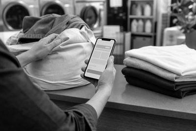Mobile laundry booking flow beside a folded customer order